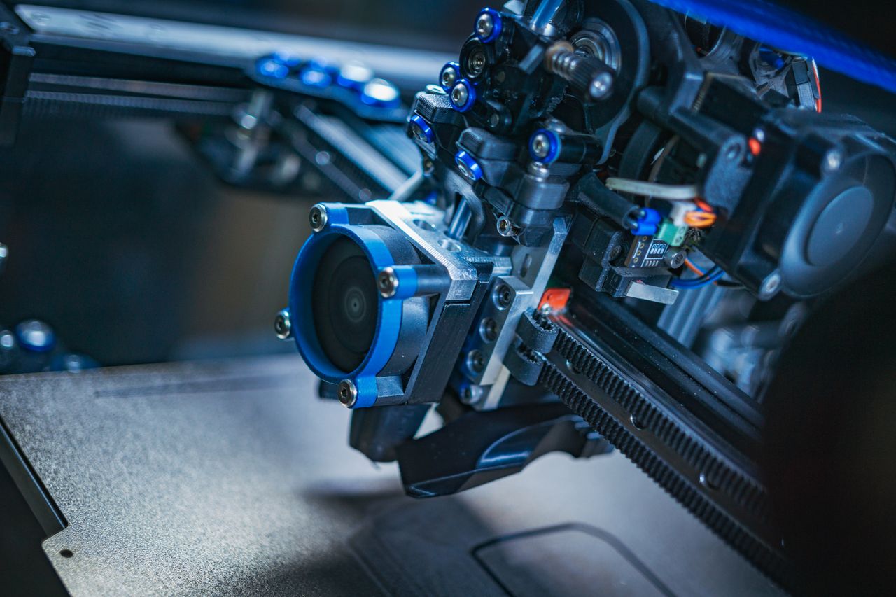 Offerings Detailed view of a high-tech 3D printer mechanism showcasing precision engineering.